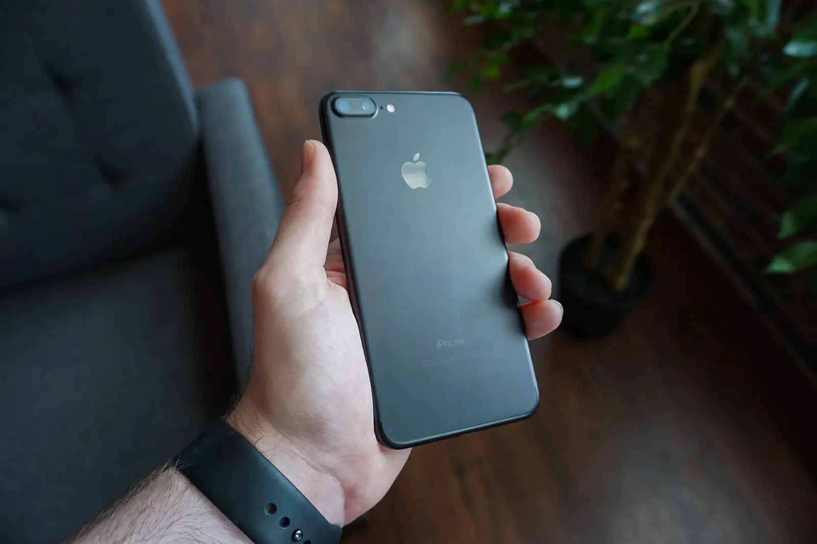 A hand holding a black iPhone